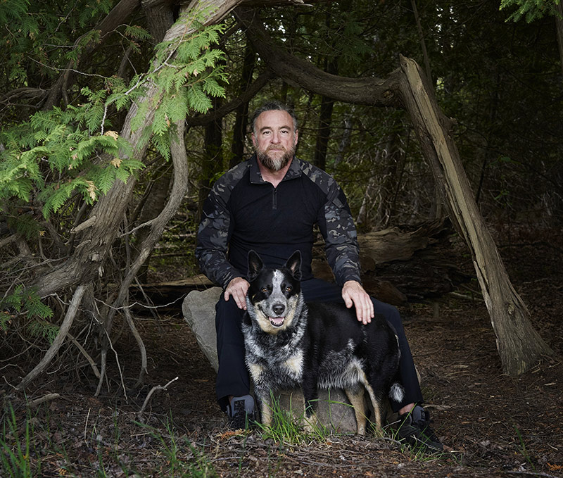 Jason Shute with dog in forest